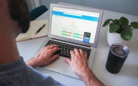 homme travaillant sur laptop affichant un site de décoration d'intérieur haut de gamme