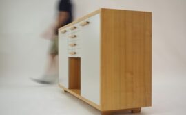 person walking beside white and brown wooden sideboard