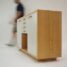 person walking beside white and brown wooden sideboard