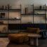 Modern living room with modular shelves and mustard armchair.