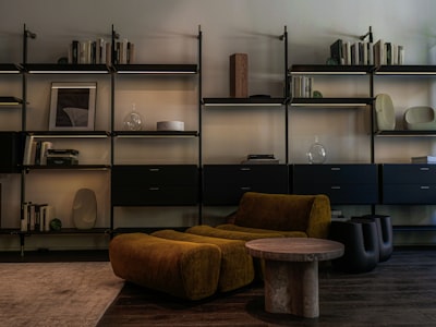 Modern living room with modular shelves and mustard armchair.