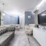 Modern light room with couch and TV on wall near armchair furnished with table and chairs next to cabinets
