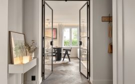 A hallway leading to a dining room with a table and chairs