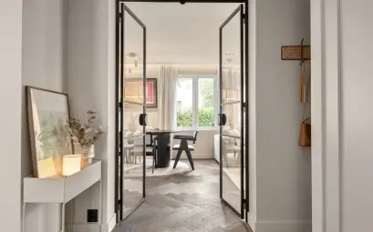 A hallway leading to a dining room with a table and chairs
