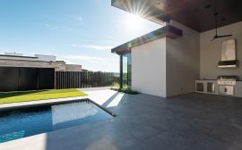 Modern outdoor patio with a swimming pool and outdoor kitchen.