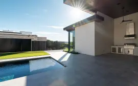 Modern outdoor patio with a swimming pool and outdoor kitchen.
