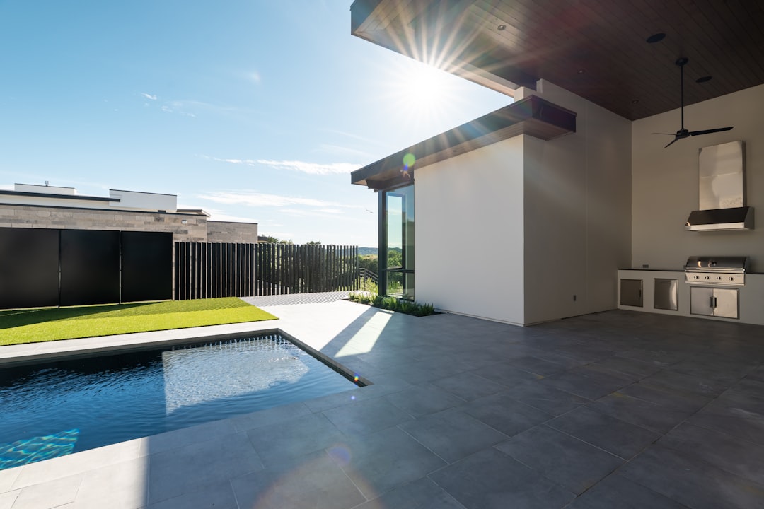 Modern outdoor patio with a swimming pool and outdoor kitchen.