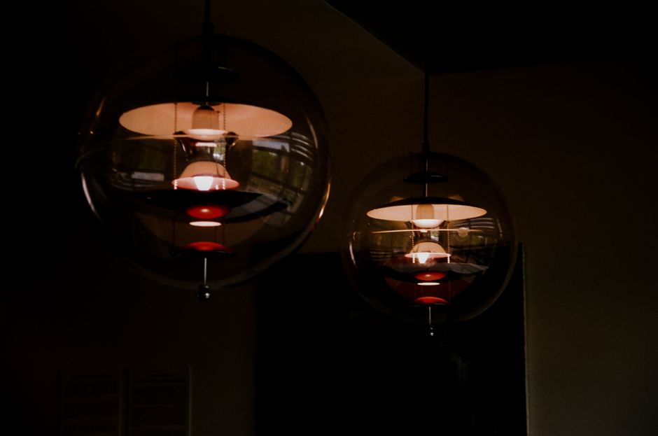 Stylish spherical pendant lights casting warm glow in a dim indoor setting.