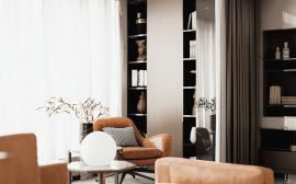 Elegant interior with an armchair, round lamp, and filled bookshelves.