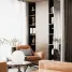 Elegant interior with an armchair, round lamp, and filled bookshelves.