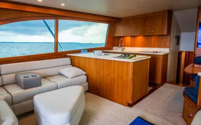 Spacious and elegantly designed yacht interior showcasing wooden furnishings and ocean view.