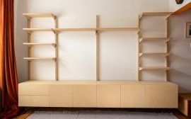 A modern light wood wall unit with shelves and cabinets