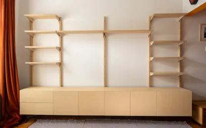 A modern light wood wall unit with shelves and cabinets