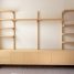 A modern light wood wall unit with shelves and cabinets