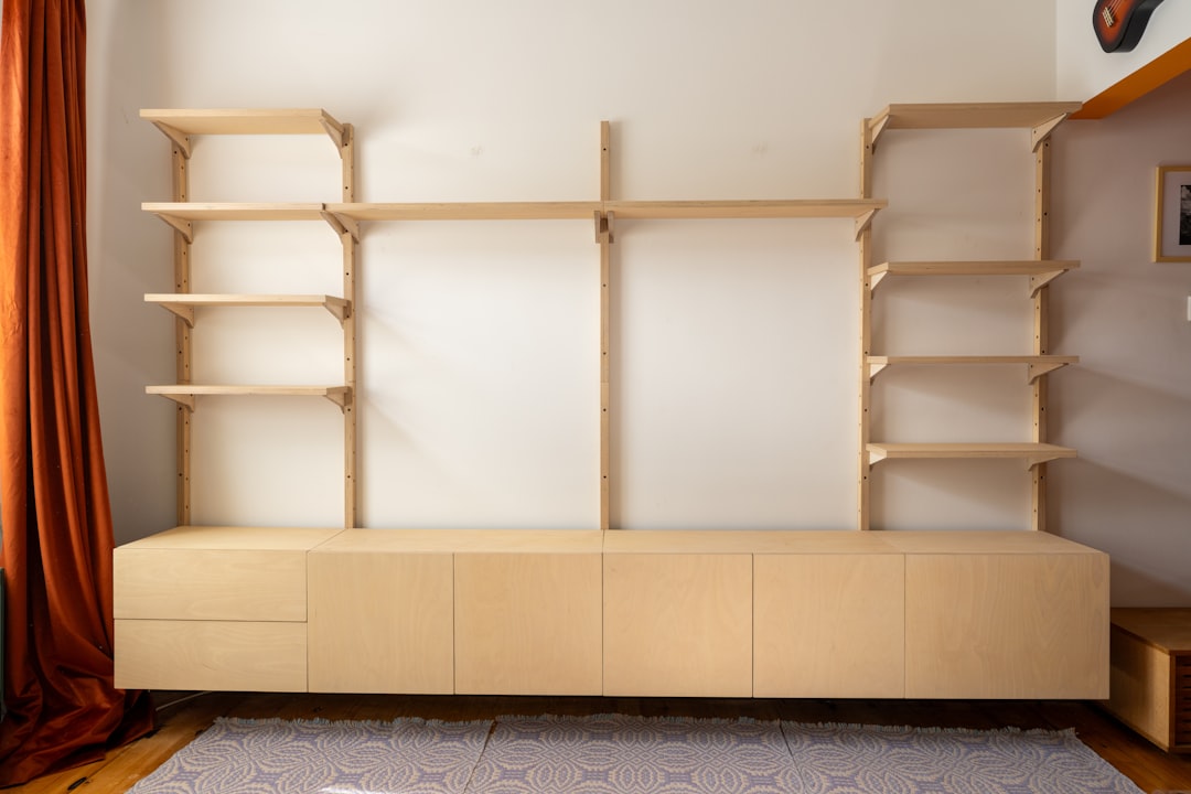 A modern light wood wall unit with shelves and cabinets