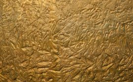 a close up of a metal surface with gold paint