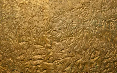 a close up of a metal surface with gold paint