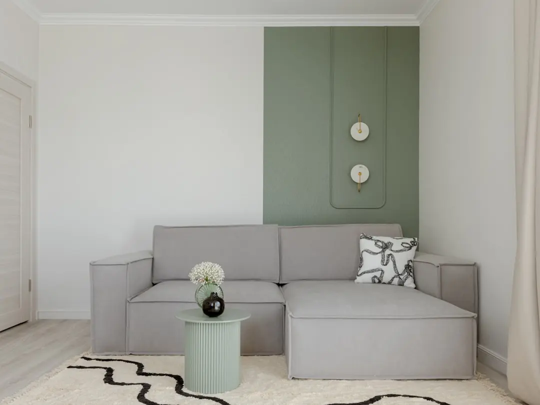 Modern living room with gray sofa and green accent wall