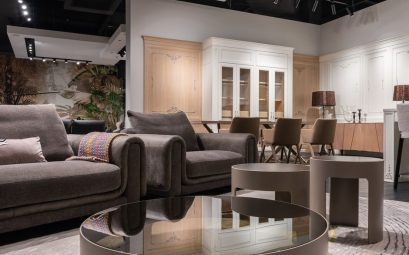Comfortable sofa and armchair placed near round tables near chairs at dining table at cupboards with decorations in spacious room