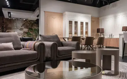 Comfortable sofa and armchair placed near round tables near chairs at dining table at cupboards with decorations in spacious room
