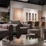 Comfortable sofa and armchair placed near round tables near chairs at dining table at cupboards with decorations in spacious room