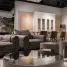 Comfortable sofa and armchair placed near round tables near chairs at dining table at cupboards with decorations in spacious room